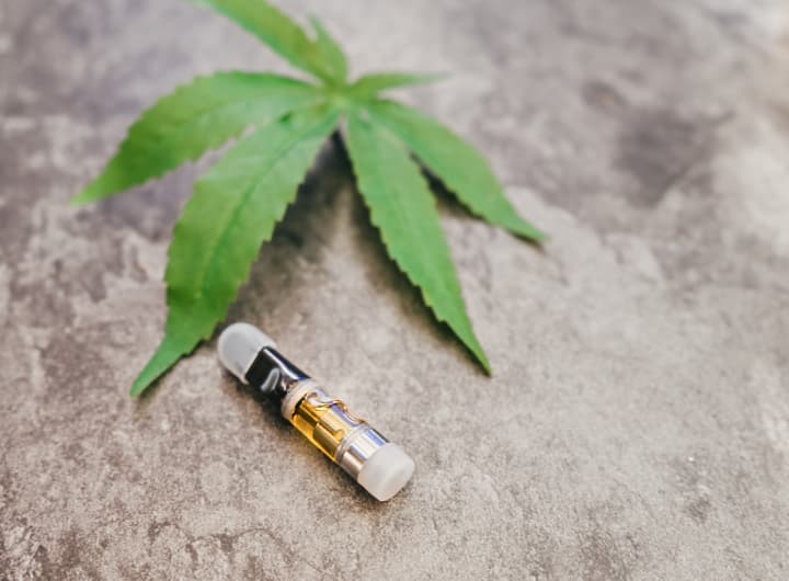 marijuana leaf with a small cartridge on a rock